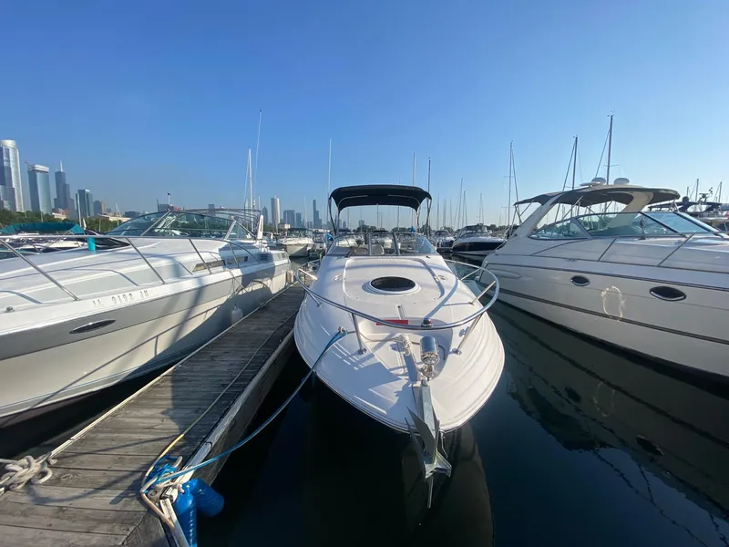 Slide: The Image of 2004 Regal 2665 Commodore docked at marina with city skyline. - 2