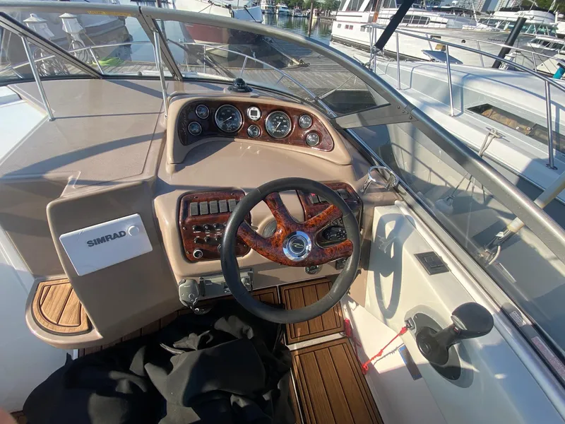 Slide: The Image of 2004 Regal 2665 Commodore boat helm with wooden steering wheel and control panel. - 22
