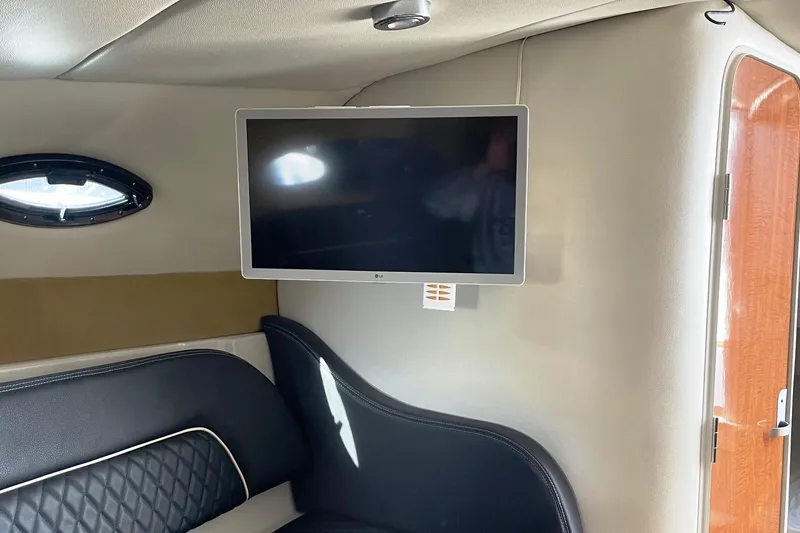 Slide: The Image of Interior of 2004 Regal Commodore 2665 with mounted TV and black seating. - 29