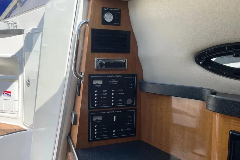 Slide: The Image of 2004 Regal Commodore 2665 boat interior control panel with wood finish and gauges. - 31