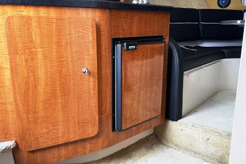 Slide: The Image of 2004 Regal Commodore 2665 cabin interior with wood cabinetry and compact refrigerator. - 33