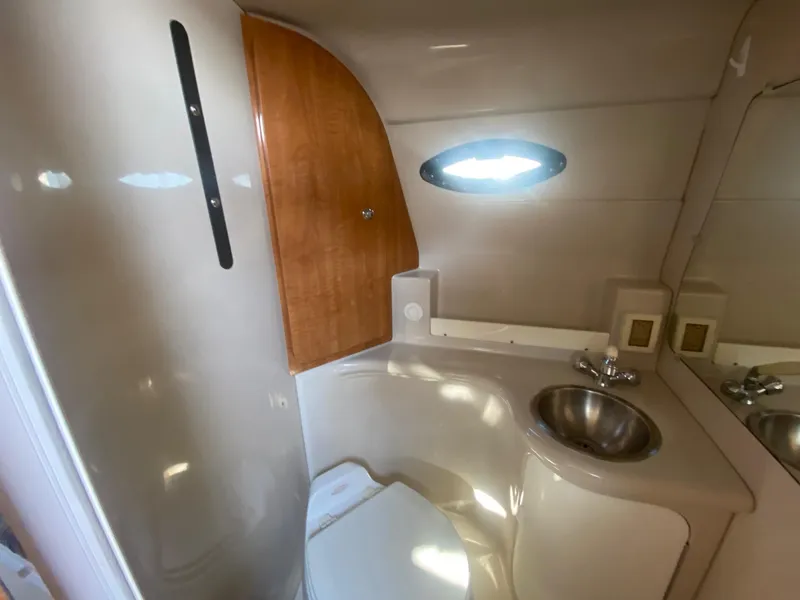 Slide: The Image of 2004 Regal 2665 Commodore boat bathroom with sink, toilet, and wooden cabinet. - 37