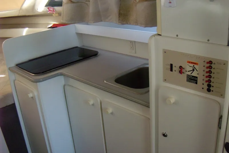 Slide: The Image of 1994 Bayliner 2859 Classic Cruiser interior kitchen with sink and control panel. - 12