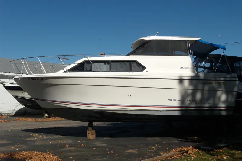 Slide: The Image of 1994 Bayliner 2859 Classic Cruiser boat on dry dock under clear blue sky. - 3