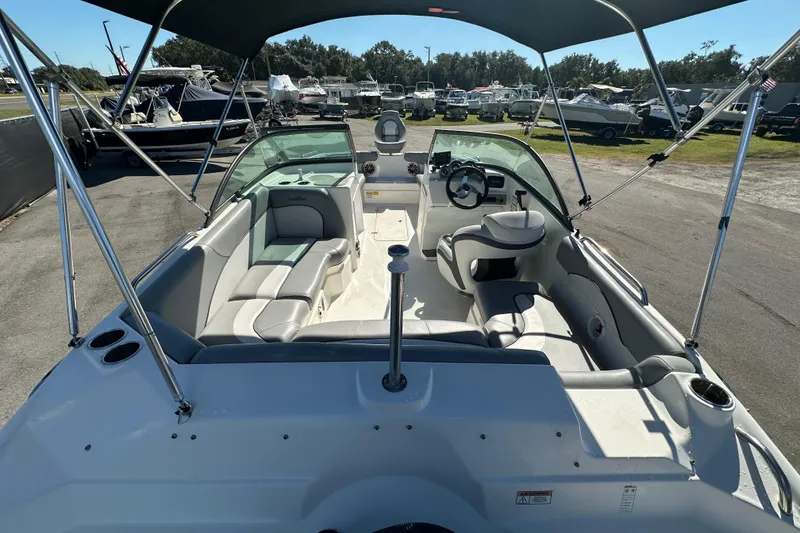 Slide: The Image of 2021 NauticStar 203 DC boat interior with seating and steering wheel under canopy. - 17