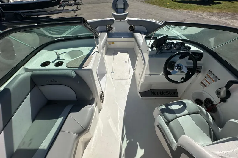 Slide: The Image of 2021 NauticStar 203 DC boat interior with seating, steering wheel, and dashboard controls. - 25