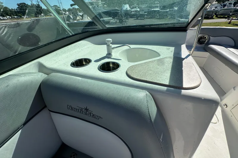Slide: The Image of 2021 NauticStar 203 DC boat interior with sink and cup holders. - 27