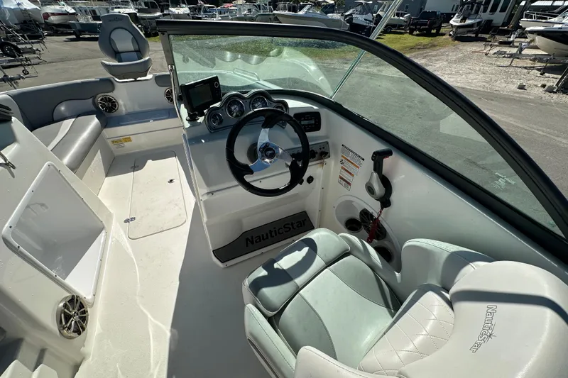 Slide: The Image of 2021 NauticStar 203 DC boat interior with steering wheel and seating. - 28