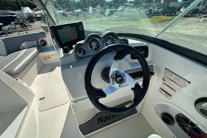 Slide: The Image of 2021 NauticStar 203 DC boat dashboard with steering wheel and navigation system. - 29