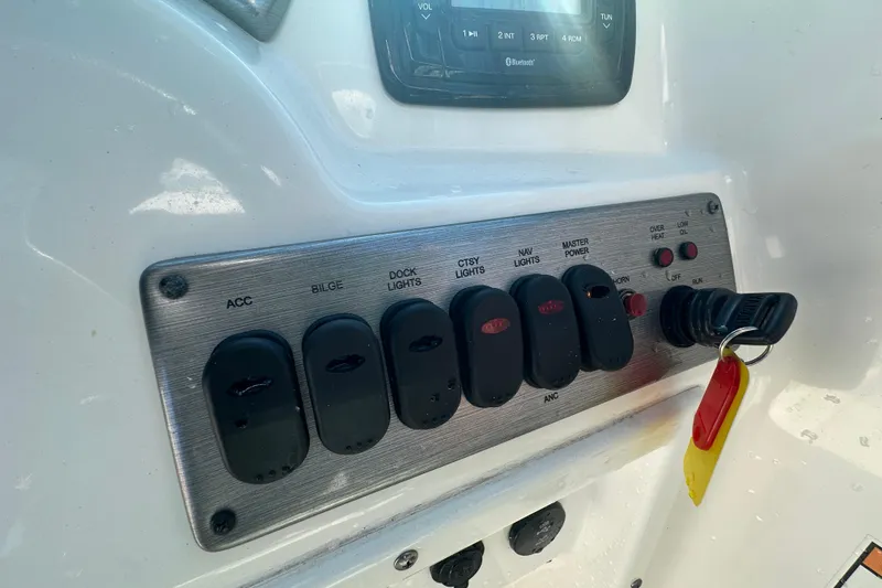 Slide: The Image of Control panel of a 2021 NauticStar 203 DC boat with switches and key. - 34