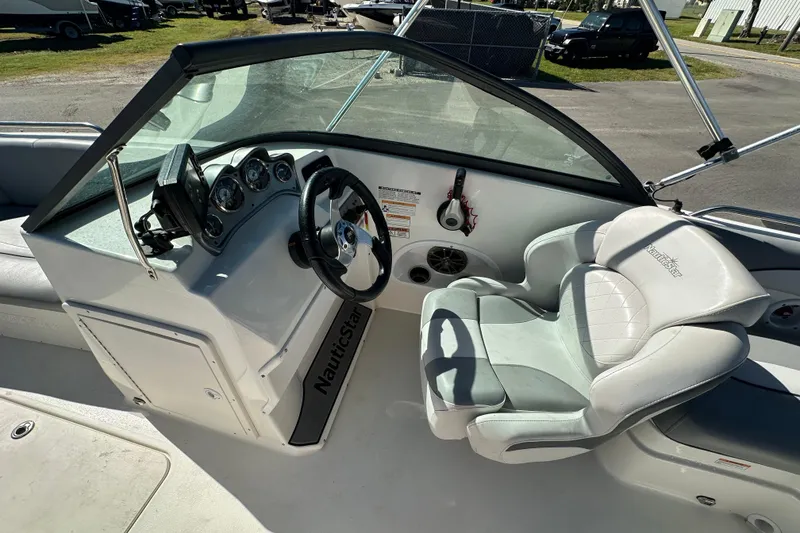 Slide: The Image of 2021 NauticStar 203 DC boat cockpit with steering wheel and comfortable seating. - 38