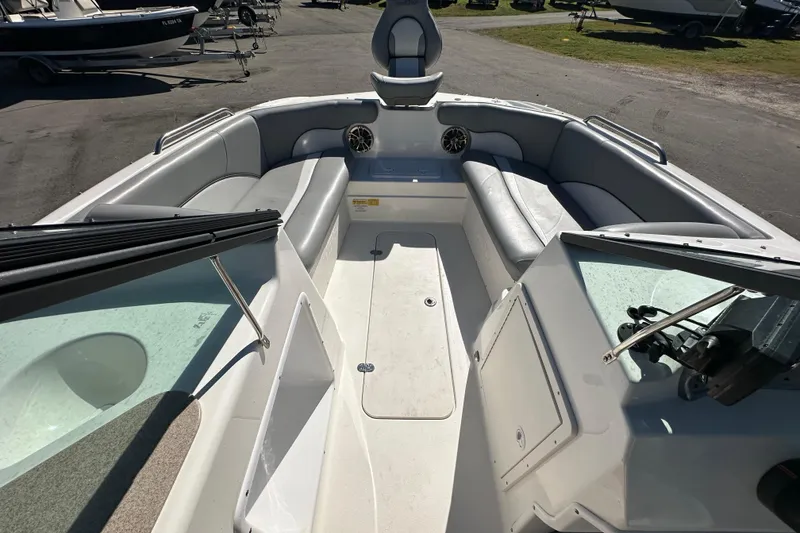 Slide: The Image of 2021 NauticStar 203 DC boat interior with seating and speakers, parked outdoors. - 40