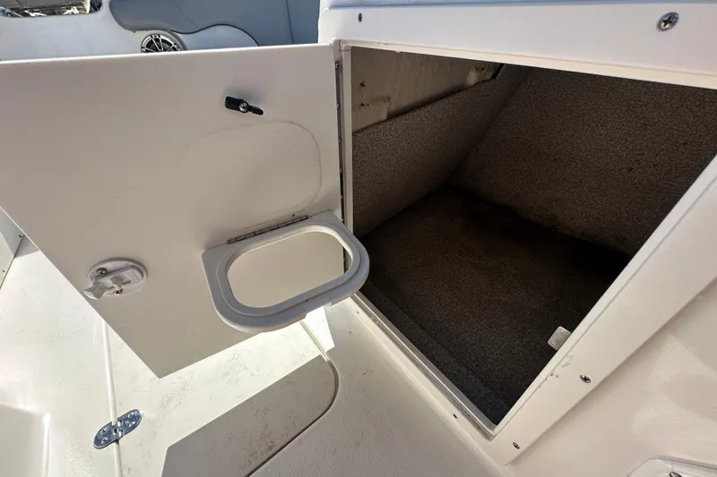 Slide: The Image of Open storage compartment on 2021 NauticStar 203 DC boat, featuring carpeted interior. - 43
