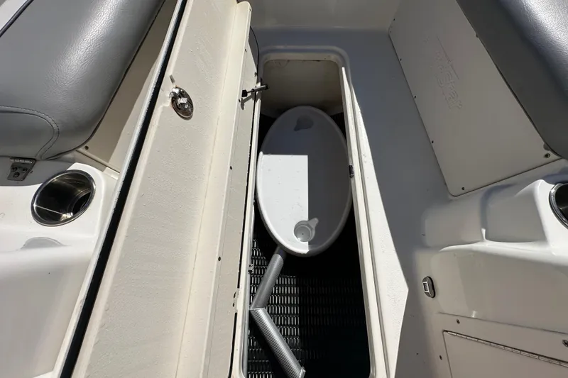 Slide: The Image of 2021 NauticStar 203 DC boat storage compartment with white interior and cup holder. - 46