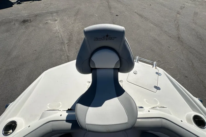 Slide: The Image of 2021 NauticStar 203 DC boat seat, white and gray upholstery, outdoor setting. - 55