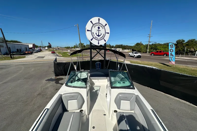 Slide: The Image of 2021 NauticStar 203 DC boat displayed outdoors under clear blue sky. - 59