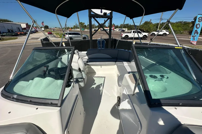 Slide: The Image of 2021 NauticStar 203 DC boat with dual consoles and seating, parked outdoors. - 69