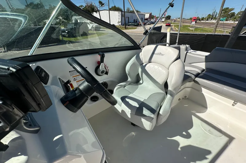 Slide: The Image of 2021 NauticStar 203 DC boat interior with steering wheel and seating area. - 71