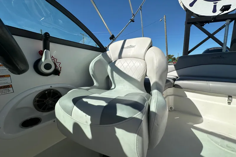 Slide: The Image of 2021 NauticStar 203 DC boat interior with white seating and steering wheel. - 72