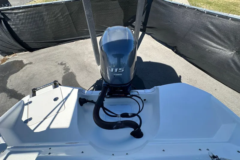Slide: The Image of 2021 NauticStar 203 DC boat with Yamaha 115 outboard motor, parked on pavement. - 89