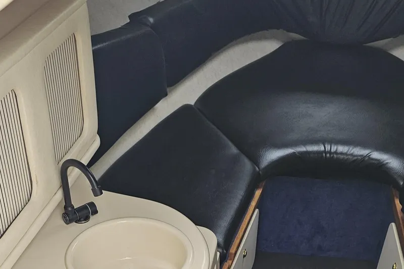 Slide: The Image of 1999 Sea Ray 260 Sundancer cabin interior with sink and seating area. - 10