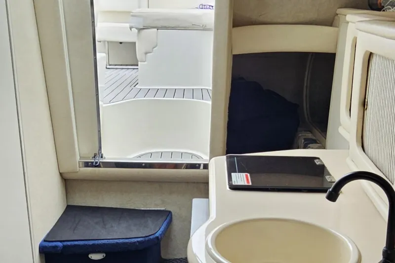 Slide: The Image of Interior of 1999 Sea Ray 260 Sundancer boat with sink and seating area. - 11