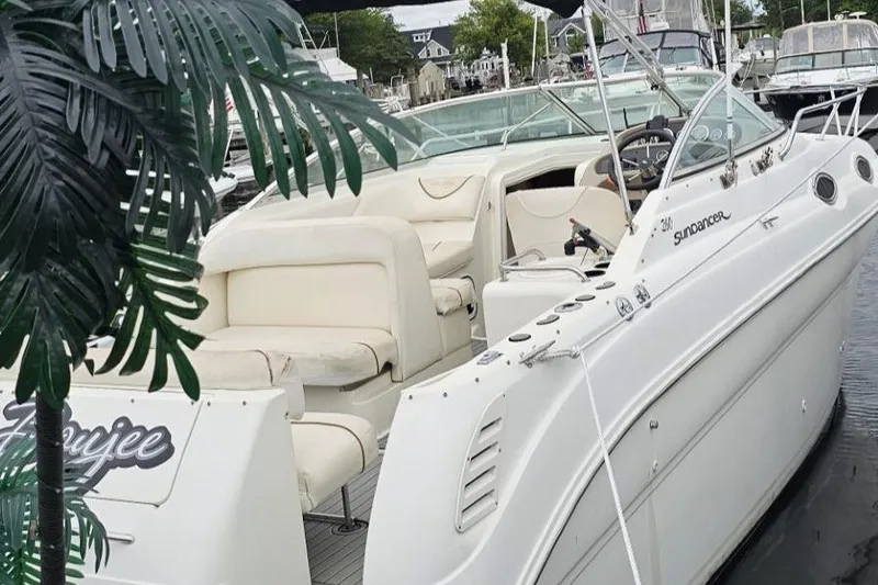 Slide: The Image of 1999 Sea Ray 260 Sundancer boat docked, featuring white exterior and spacious seating. - 13