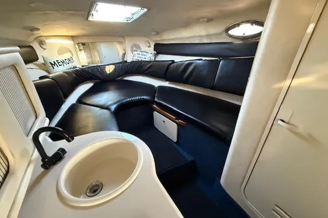 Slide: The Image of 1999 Sea Ray 260 Sundancer cabin interior with leather seating and compact sink. - 18
