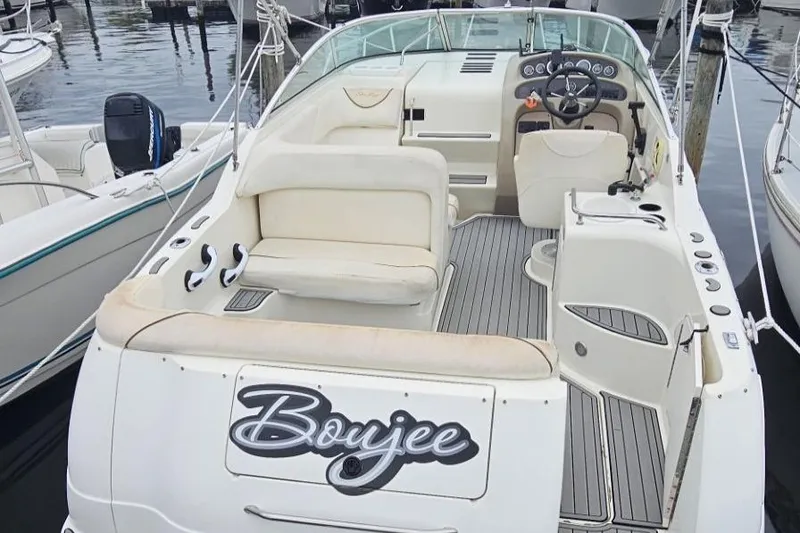 Slide: The Image of 1999 Sea Ray 260 Sundancer boat docked, featuring spacious seating and sleek design. - 5