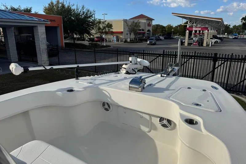 Slide: The Image of 2021 Twin Vee 260 CC GF boat with modern equipment, parked near a commercial area. - 13