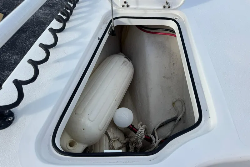 Slide: The Image of Storage compartment on a 2021 Twin Vee 260 CC GF boat, containing a fender and ropes. - 15