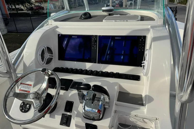 Slide: The Image of 2021 Twin Vee 260 CC GF boat dashboard with dual Simrad displays and steering wheel. - 21