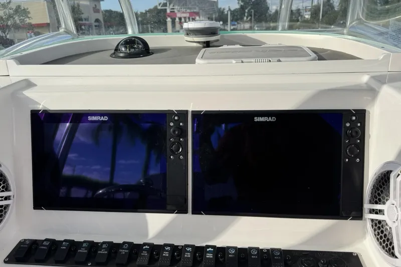 Slide: The Image of 2021 Twin Vee 260 CC GF boat dashboard with dual Simrad displays and control panel. - 22