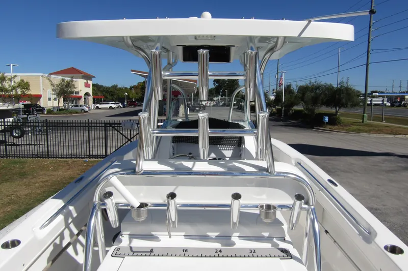 Slide: The Image of 2021 Twin Vee 260 CC GF boat with T-top and rod holders, parked outdoors. - 27
