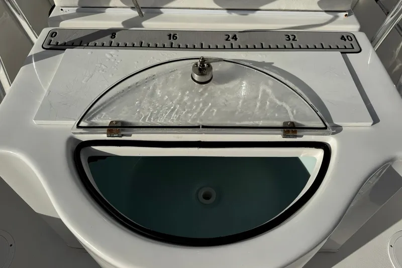 Slide: The Image of 2021 Twin Vee 260 CC GF boat livewell with measuring ruler on lid. - 29