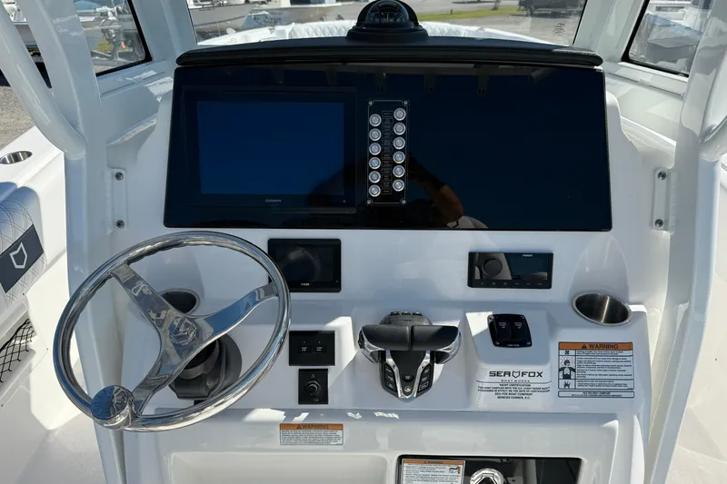 Slide: The Image of 2026 Sea Fox 268 Commander boat dashboard with steering wheel and electronic controls. - 20