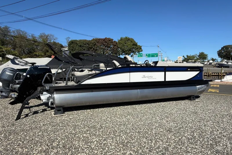 The Image of 2026 Barletta C24UC pontoon boat displayed outdoors on gravel lot. - 0