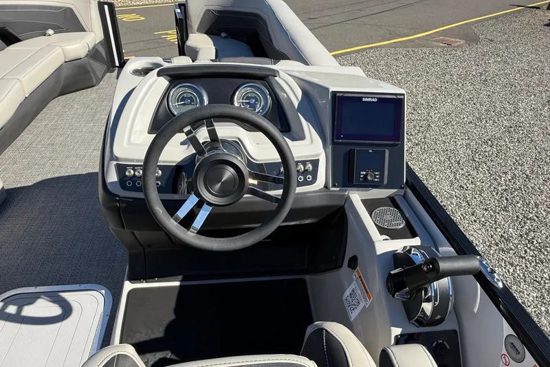 Slide: The Image of 2026 Barletta C24UC boat dashboard with steering wheel and navigation controls. - 3