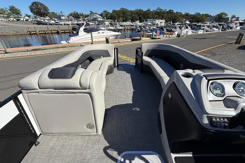 Slide: The Image of 2026 Barletta C24UC pontoon boat interior with plush seating and modern dashboard at marina. - 5