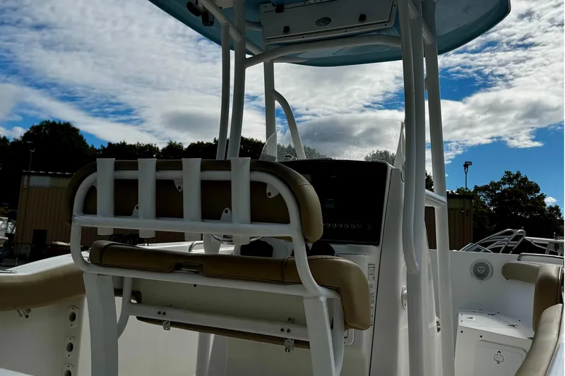 Slide: The Image of 2016 Tidewater 232 CC Adventure boat interior with console and seating under blue sky. - 10