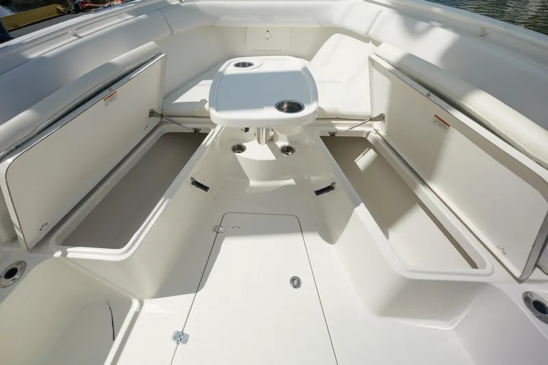 Slide: The Image of 2015 Sailfish 320 CC boat interior with open storage compartments and table. - 17