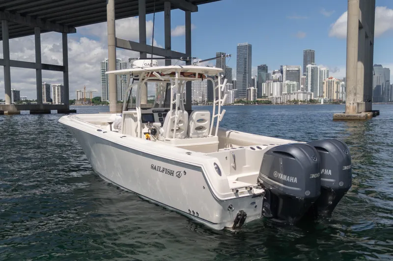 Slide: The Image of 2015 Sailfish 320 CC boat with Yamaha engines, city skyline in background. - 2