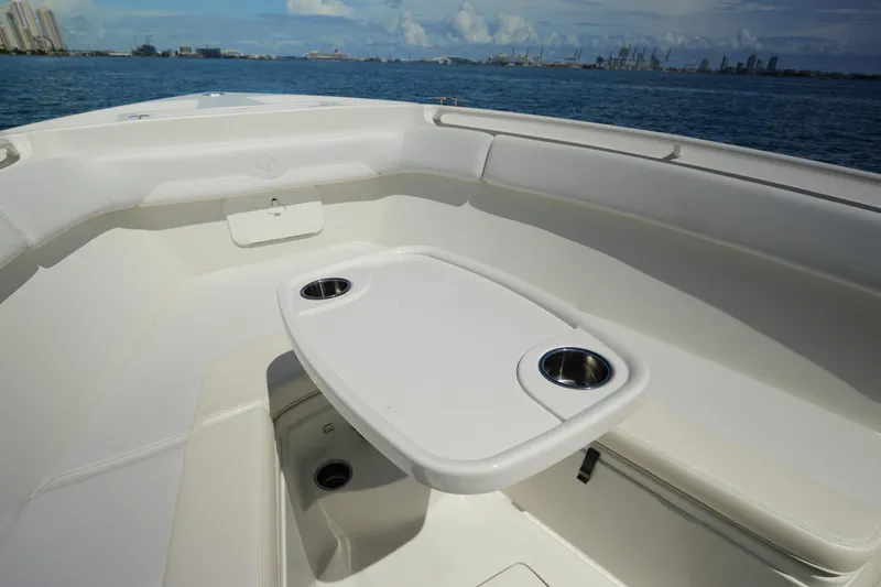 Slide: The Image of 2015 Sailfish 320 CC boat interior with table and cup holders, ocean view. - 20