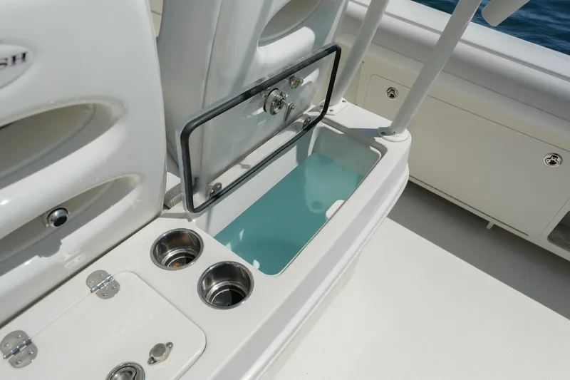 Slide: The Image of 2015 Sailfish 320 CC boat interior with open storage compartment and cup holders. - 21