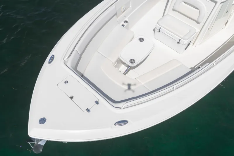 Slide: The Image of 2015 Sailfish 320 CC boat interior with seating and table, on calm water. - 4