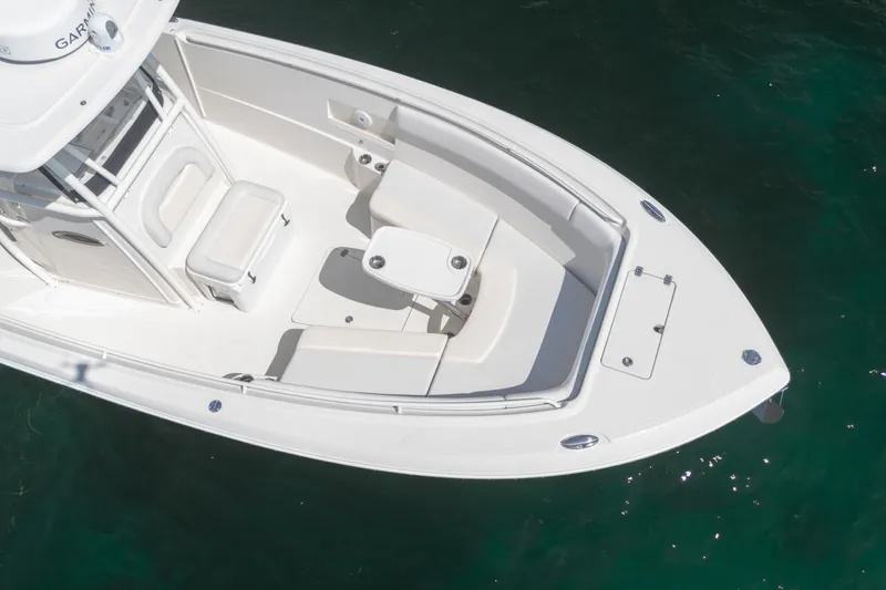 Slide: The Image of 2015 Sailfish 320 CC boat with white seating and table, floating on clear water. - 5