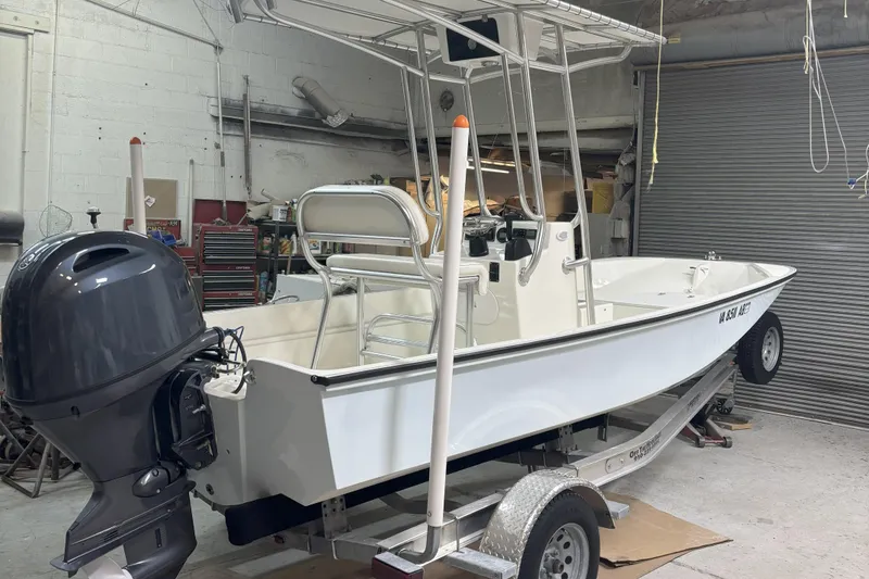 Slide: The Image of 1978 Boston Whaler 17 Montauk boat in garage, on trailer, with outboard motor. - 1