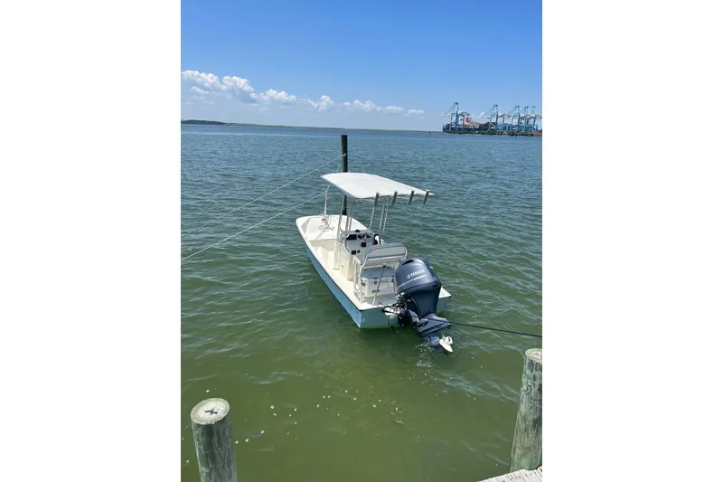 Slide: The Image of 1978 Boston Whaler 17 Montauk boat docked on calm water under clear blue sky. - 2