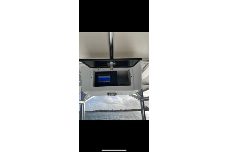 Slide: The Image of 1978 Boston Whaler 17 Montauk boat with electronic display, overlooking a scenic water view. - 4