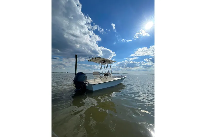 Slide: The Image of 1978 Boston Whaler 17 Montauk boat on calm water under a bright blue sky. - 8